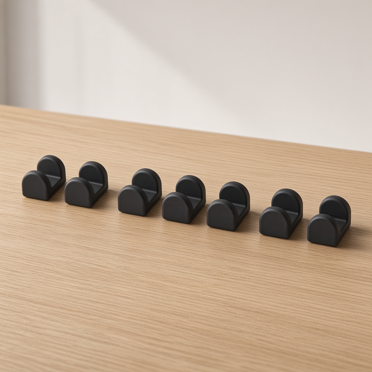 Eight small matte black magnetic cable clips.