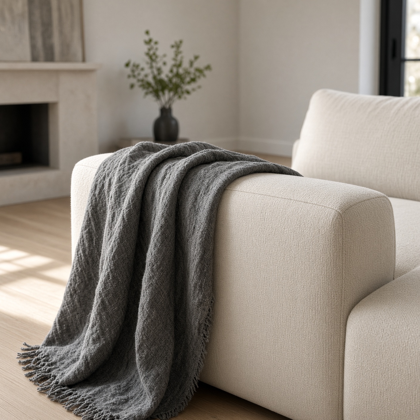 A charcoal linen throw over the arm of a sofa.