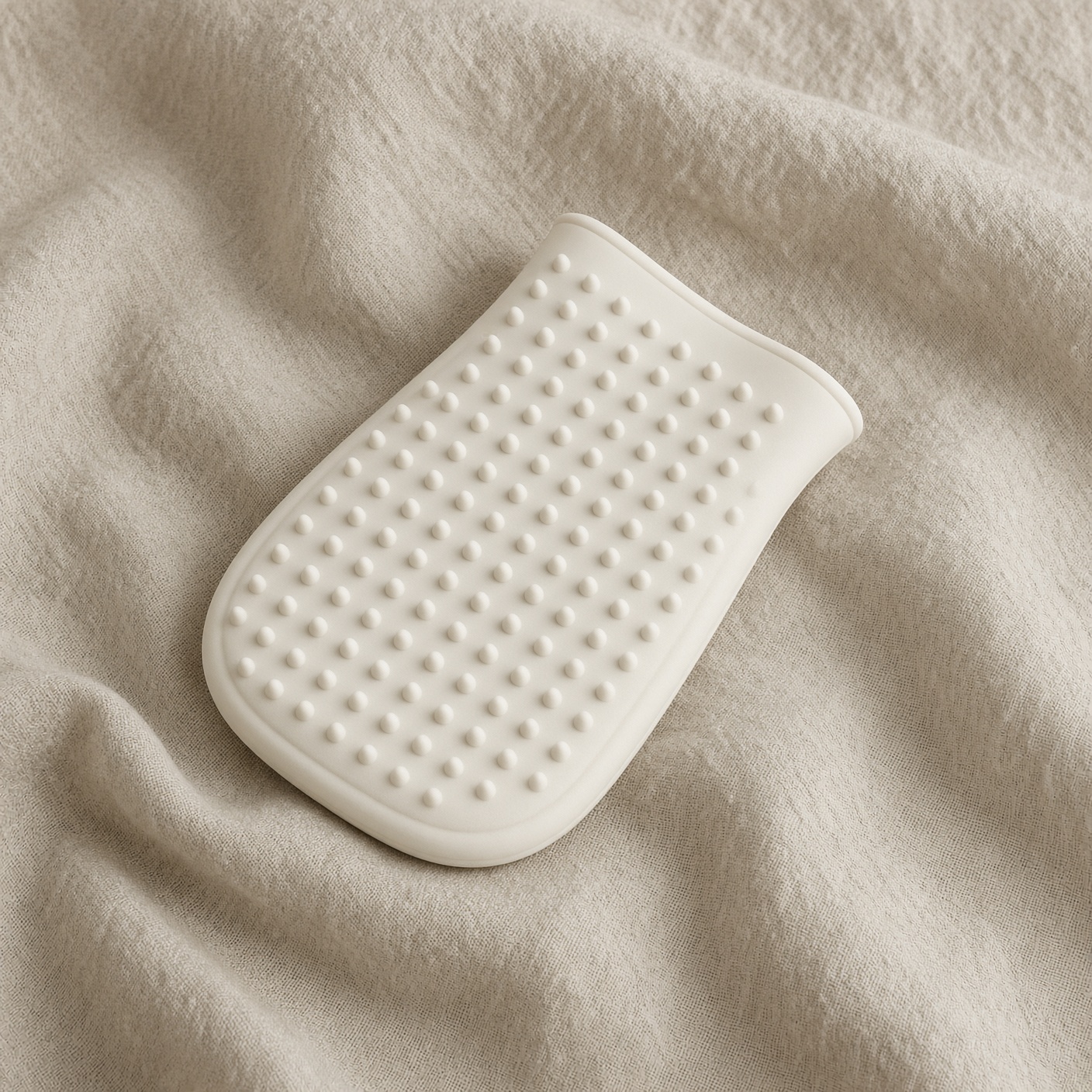 A pale rubber mitt for pet hair.
